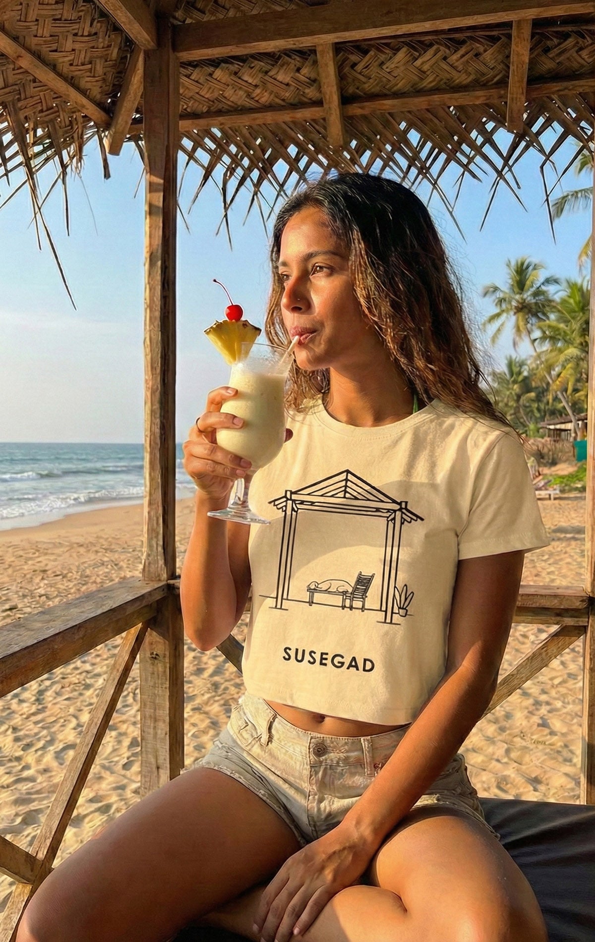 Minimal line art illustration of a Goan shack scene with a sleeping dog, chair, and plant symbolizing the Susegad laid-back lifestyle of Goa.