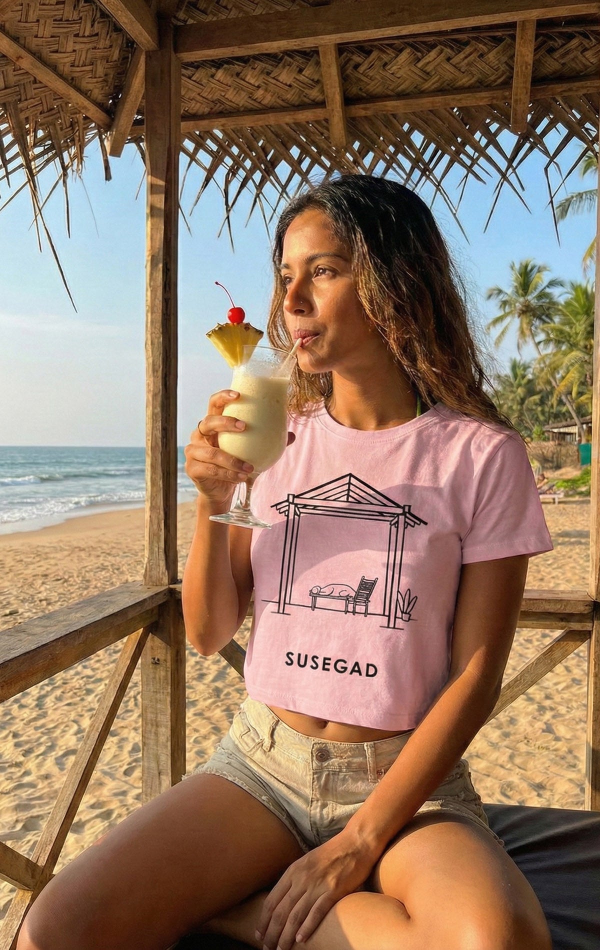 Illustration of a peaceful Goan shack with a slanted roof, a dog sleeping on a bench, a relaxed chair, and a potted plant, representing the laid-back Susegad Goan lifestyle.