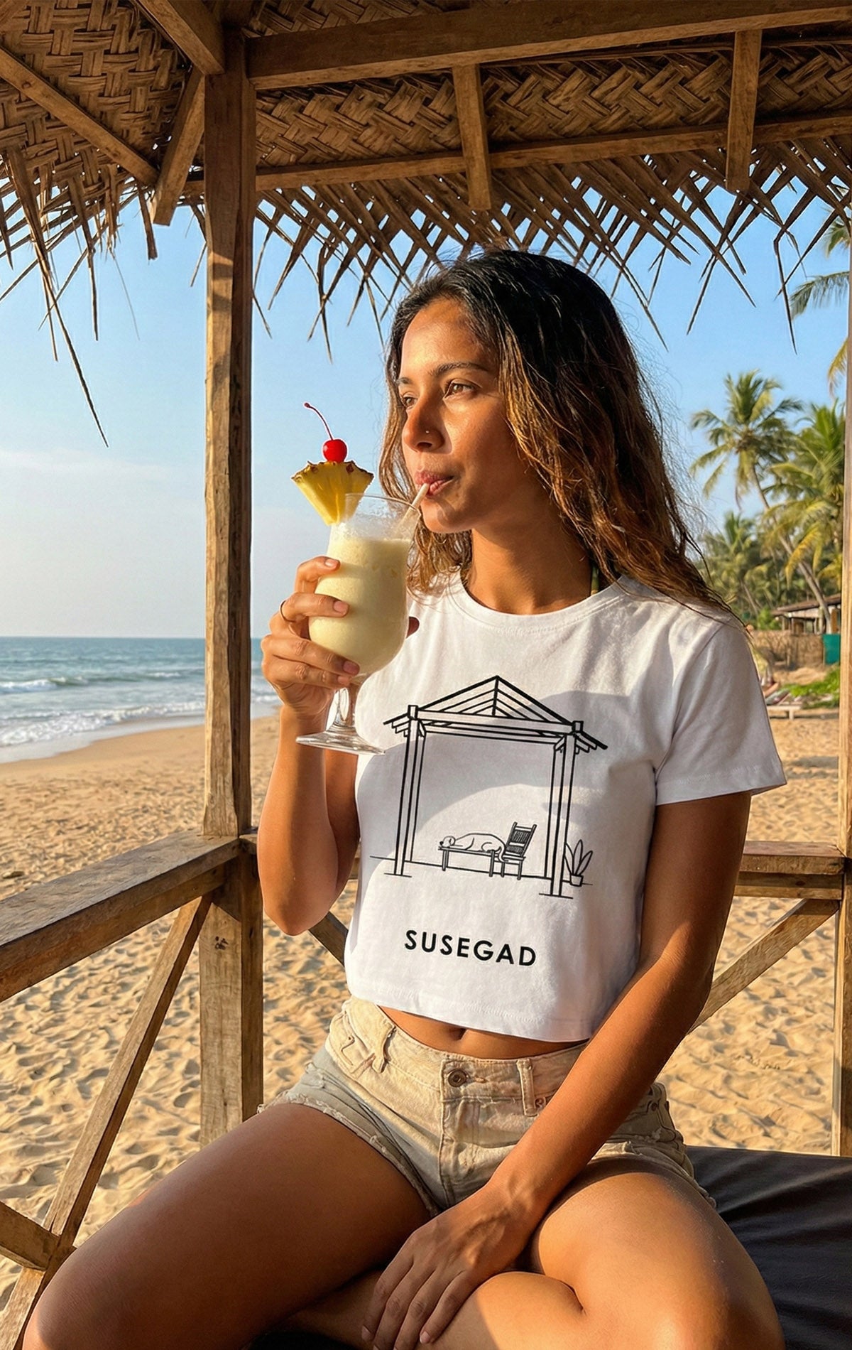 A minimalist black and white line art illustration of a dog sleeping comfortably on a traditional wooden bench under a tiled roof structure (balcão). The word "SUSEGAD" is written in bold, clean capital letters underneath. The background is a light grey.